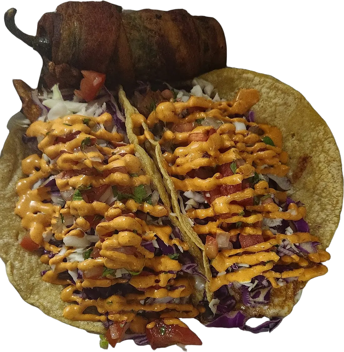 Two tacos on corn tortillas with red cabbage, pico and a chipotle cream drizzle, a roasted chile on top