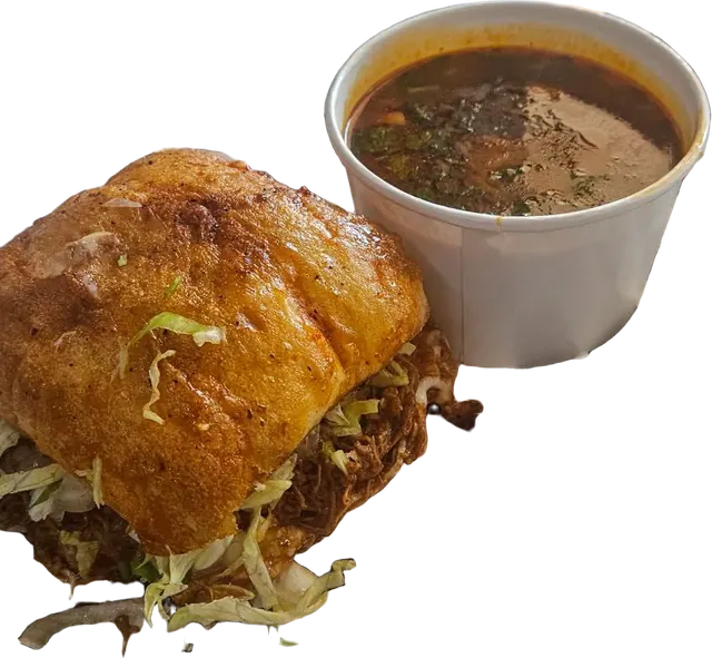 A Birria Bite: birria on a toasted roll with shredded lettuce, and a cup of consommé